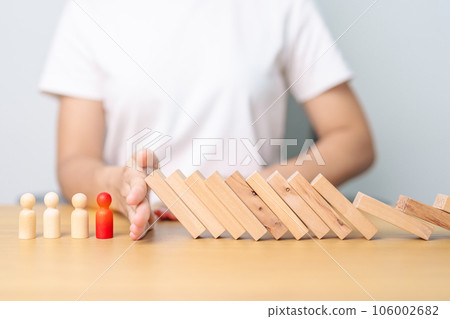 Hand stop falling wood domino blocks on table. Crisis, fall Business, Risk management, Economic recession, Strategy and solutions concept 106002682