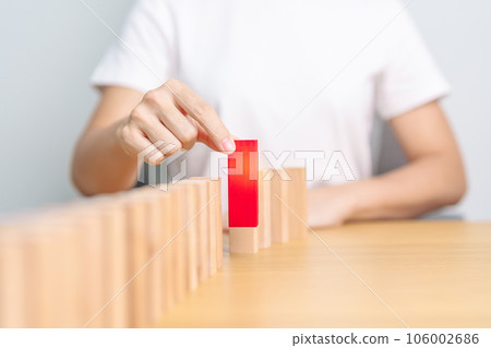hand placing or pulling Red domino wooden block on table. Business planning, Risk Management, Solution, leader, strategy, different, Hiring, Human Resource and Unique Concepts hand placing or pulling Red domino wooden block on table. Business planning, Risk Management, Solution, leader, strategy, different, Hiring, Human Resource and Unique Concepts 106002686