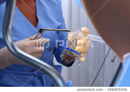 A gynecologist performs a cervical biopsy. Gynecological chair. A woman at the gynecologist for a check-up. 106005048
