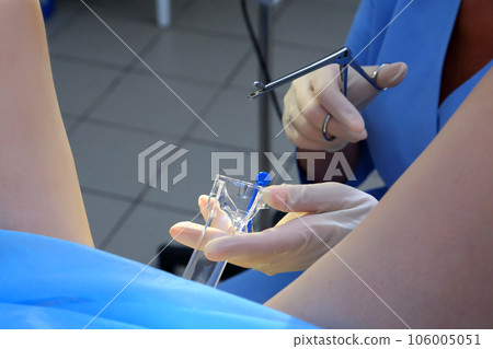 A gynecologist performs a cervical biopsy. Gynecological chair. A woman at the gynecologist for a check-up. A gynecologist performs a cervical biopsy. Gynecological chair. A woman at the gynecologist for a check-up. 106005051