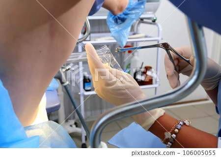 A gynecologist performs a cervical biopsy. Gynecological chair. A woman at the gynecologist for a check-up. A gynecologist performs a cervical biopsy. Gynecological chair. A woman at the gynecologist for a check-up. 106005055