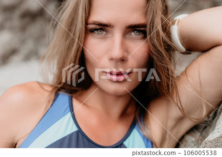 Woman summer travel sea. Happy tourist in blue bikini enjoy taking picture outdoors for memories. Woman traveler posing on the beach surrounded by volcanic mountains, sharing travel adventure journey 106005538