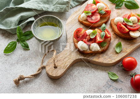 Bruschetta with tomato, basil and mozzarella cheese Bruschetta with tomato, basil and mozzarella cheese 106007238