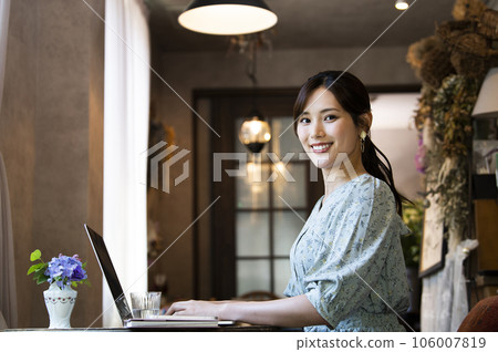 一位在咖啡館工作的年輕女子看著鏡頭 一位在咖啡館工作的年輕女子看著鏡頭 106007819
