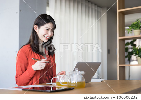 一位 30 多歲的美女在客廳的筆記本電腦前在線學習資格 一位 30 多歲的美女在客廳的筆記本電腦前在線學習資格 106008232