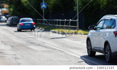Poplar fluff in the air over country road with some cars 106012185