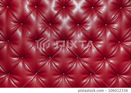 Close up background texture of red genuine leather, classic retro Chesterfield style, furniture upholstery with deep diamond pattern and buttons Close up background texture of red genuine leather, classic retro Chesterfield style, furniture upholstery with deep diamond pattern and buttons 106012336