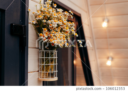 pot flowers hanging over the door with a sign that says "welcome". pot flowers hanging over the door with a sign that says "welcome". 106012353