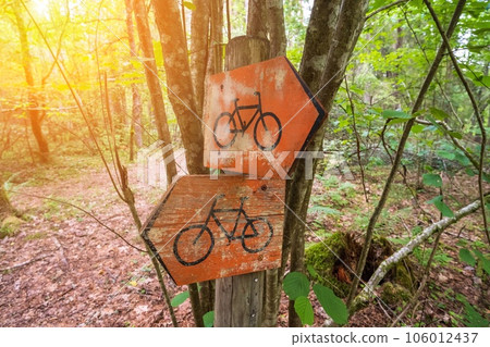 Bicycle access road traffic signs in red on a wooden post in the forest. Close-up, shallow depth of field, no people 106012437