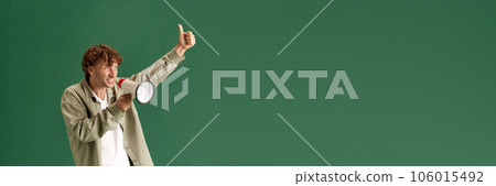 Mature man in casual clothes emotionally shouting in megaphone against green studio background 106015492