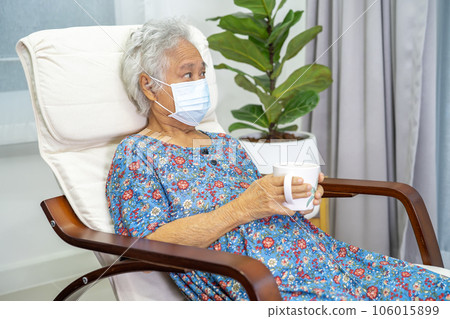 Asian elderly woman sitting and relaxing with happy in rocking chair at room in home. Asian elderly woman sitting and relaxing with happy in rocking chair at room in home. 106015899