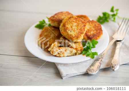 Cooked fried fish cutlets in a plate with herbs. Cooked fried fish cutlets in a plate with herbs. 106018111