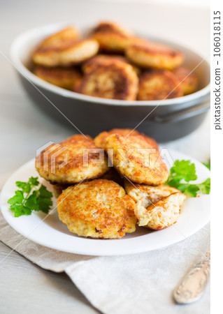 Cooked fried fish cutlets in a plate with herbs. 106018115