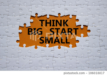 Think big start small symbol. Concept words Think big start small on white puzzle. Beautiful orange background. Business and Think big start small concept. Copy space Think big start small symbol. Concept words Think big start small on white puzzle. Beautiful orange background. Business and Think big start small concept. Copy space 106018817