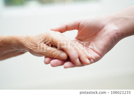 Asian young boy holding old grandmother woman hand together with love and care. 106021235