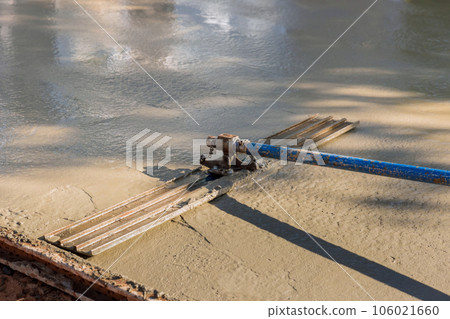Workers leveling concreting for driveway on construction site using slump concrete ready mix trowel 106021660