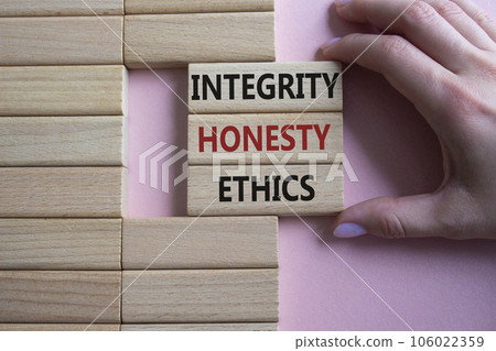 Integrity Honesty Ethics symbol. Concept words Integrity Honesty Ethics on wooden blocks. Businessman hand. Beautiful pink background. Business and Integrity Honesty Ethics concept. Copy space. 106022359