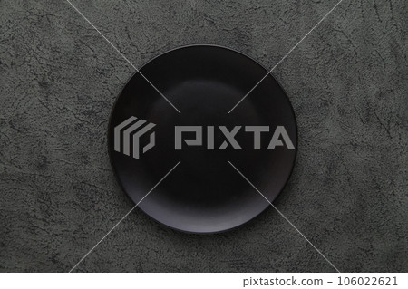 Empty Black Ceramic Plate on Black Cement background. Top view, copy space 106022621