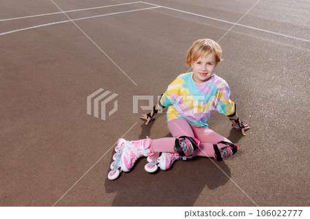 A beautiful little girl learns to roller skate  106022777