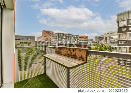 a balcony with grass and buildings in the background, taken from an apartment building's roof top deck area 106023485