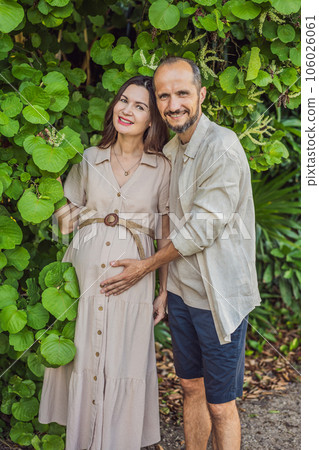 A blissful scene in the park as a radiant pregnant woman after 40 and her loving husband after 40, cherish the joy of parenthood together, surrounded by nature's serenity 106026061