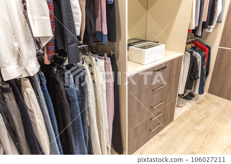 Big wardrobe with different clothes for dressing room 106027211