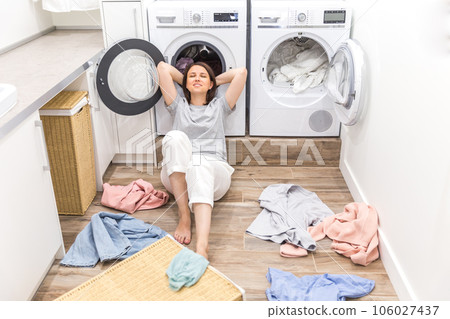 happy woman housewife in the laundry room near the washing machine with dirty clothes happy woman housewife in the laundry room near the washing machine with dirty clothes 106027437