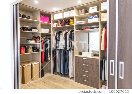 Big wardrobe with different clothes for dressing room 106027663