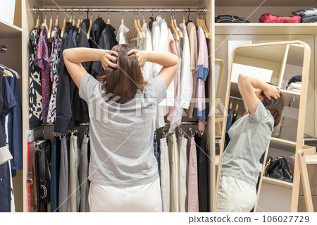 Beautiful girl is choosing clothes in her dressing room 106027729