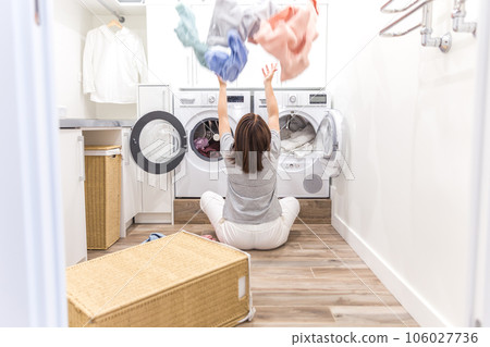 Happy family mother housewife in laundry room with washing machine throwing clothes up Happy family mother housewife in laundry room with washing machine throwing clothes up 106027736