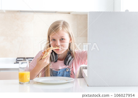 little girl eating pizza sitting at the table little girl eating pizza sitting at the table 106027954