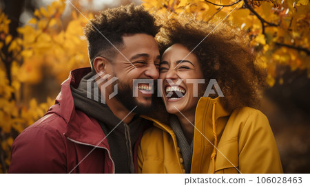 Happy warmly dressed young loving multi-ethnic couple laughing as they enjoy the beautiful fall leaves in the park - Generative AI. Happy warmly dressed young loving multi-ethnic couple laughing as they enjoy the beautiful fall leaves in the park - Generative AI. 106028463