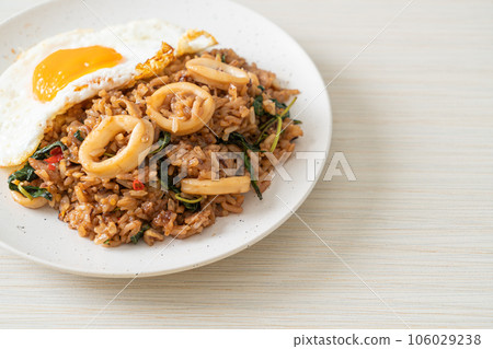 fried rice with squid and basil topped fried egg in Thai style fried rice with squid and basil topped fried egg in Thai style 106029238