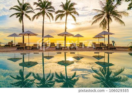 Umbrella and chair around swimming pool in resort hotel for leisure travel and vacation neary sea ocean beach 106029385
