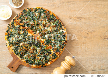 spinach and cheese pizza on wood tray 106030583