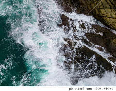Waves crashing on seashore rocks,Top view sea surface waves background 106031039