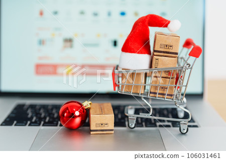 Christmas Online Shopping concept. Boxes with shopping cart on a laptop computer. Sale and discount during Christmas and New Year holiday, ecommerce, shipping delivery, logistics and Cyber Monday 106031461