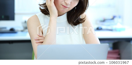 Image of a female office worker who is worried or troubled in front of a computer 106031967