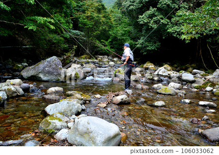 An angler fishing in the mountain stream near Hiraname Falls on the Kawazu River An angler fishing in the mountain stream near Hiraname Falls on the Kawazu River 106033062