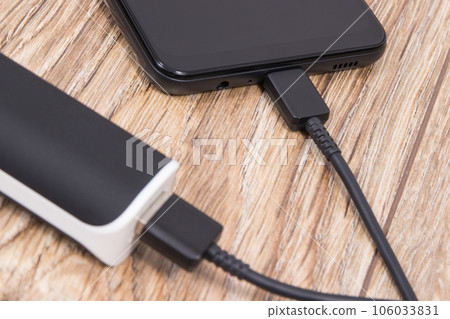 External powerbank using to charge empty battery of black smartphone External powerbank using to charge empty battery of black smartphone 106033831