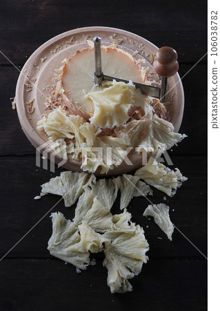 Slice the tete des Moines cheese with a girolle knife. A kind of Swiss semi-hard cheese. A special cheese knife.Vertical photo. 106038782