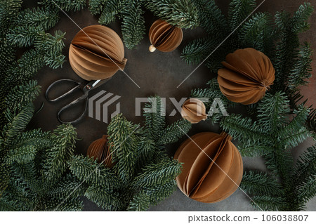 Christmas toys made of paper. Handmade work. Craft paper. Spruce branches. Vertical photo. Greeting card for holiday. New Year or Christmas. Christmas toys made of paper. Handmade work. Craft paper. Spruce branches. Vertical photo. Greeting card for holiday. New Year or Christmas. 106038807