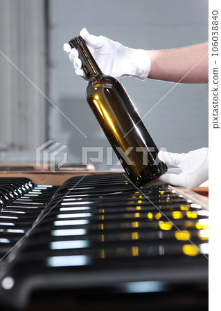 Wine storage.New wine is bottled and stacked.Bottled wine at winery.Hands in white gloves. Wine storage.New wine is bottled and stacked.Bottled wine at winery.Hands in white gloves. 106038840
