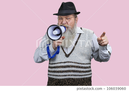 Expressive aged man giving a speech in megaphone. Isolated on pink background. 106039060