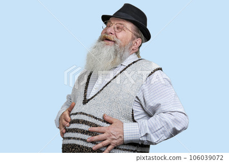Old senior man laughing and touching his stomach. Isolated on blue background. 106039072