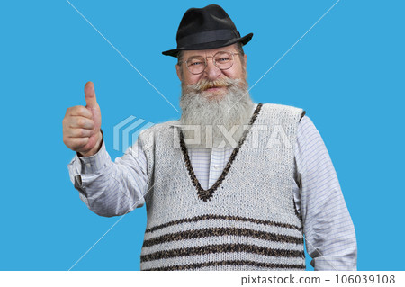 Handsome senior man shows thumb up. Isolated on blue. 106039108