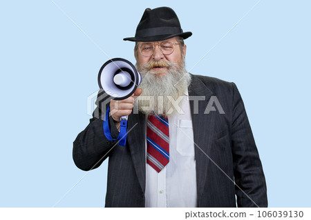 Portrait of aged senior man shouting in megaphone. Pastel blue background. 106039130