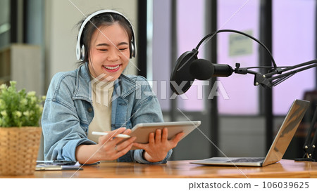 Young woman podcaster wearing headphone recording podcast from studio. Radio, podcasts, blogging and technology concept Young woman podcaster wearing headphone recording podcast from studio. Radio, podcasts, blogging and technology concept 106039625