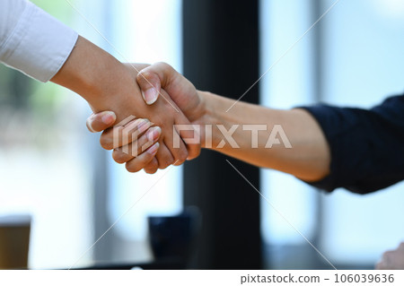 Cropped image of businesspeople shaking hands closing deal or making agreement after successful negotiations 106039636
