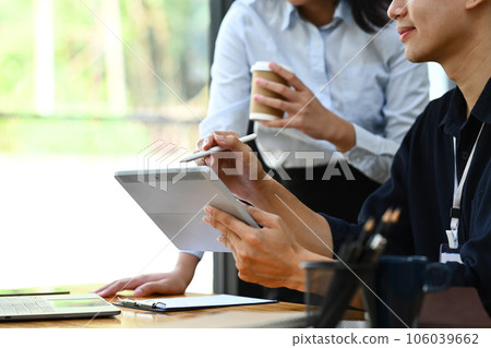 Cropped image of office workers are discussing project planning and advising on financial data report at workplace. Cropped image of office workers are discussing project planning and advising on financial data report at workplace. 106039662